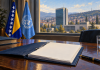 OHR upozorava na blokade iz RS-a: Šta izvještaj UN-u znači za BiH i program 5+2 Simbolična AI ilustracija izvještaja o BiH uz zastave BiH i UN-a